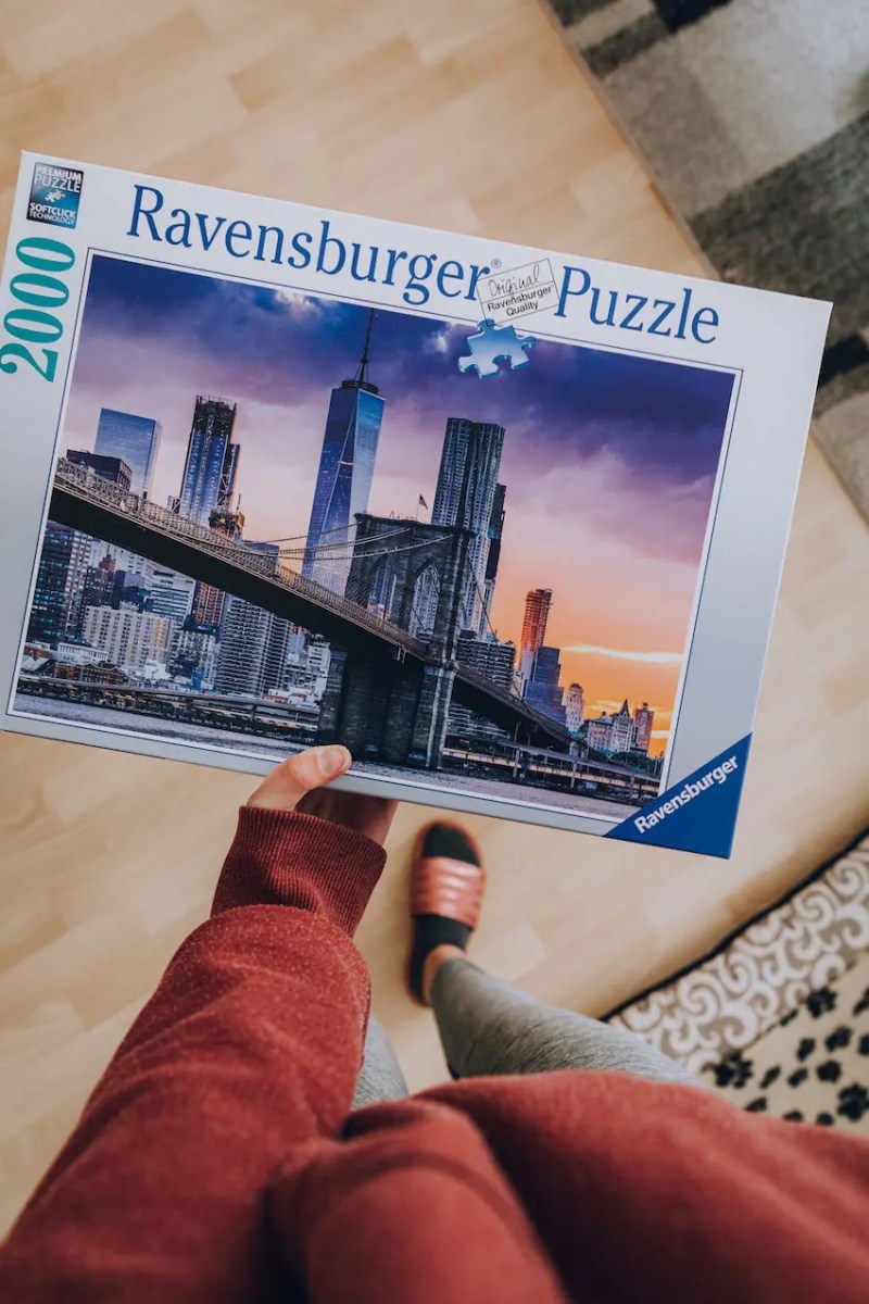 girl doing ravensburger puzzle at home