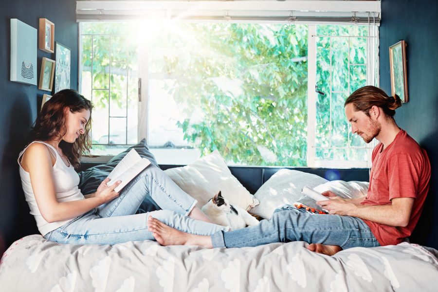 couple sitting in bed reading non-negotiables in a relationship