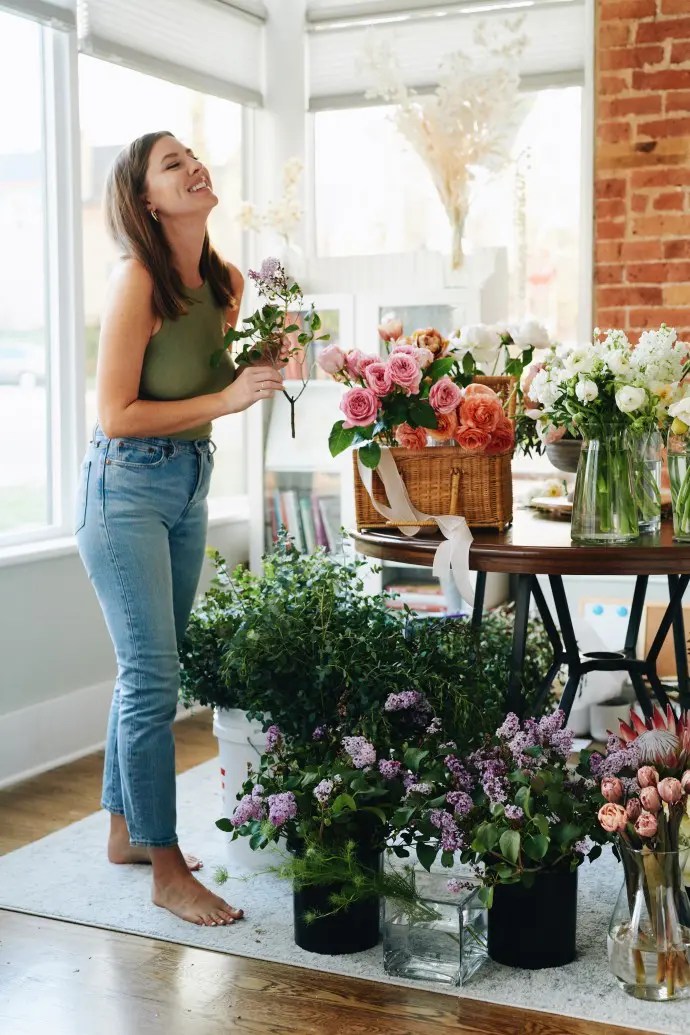 woman working through the burnout and feeling happy surrounded by flowers