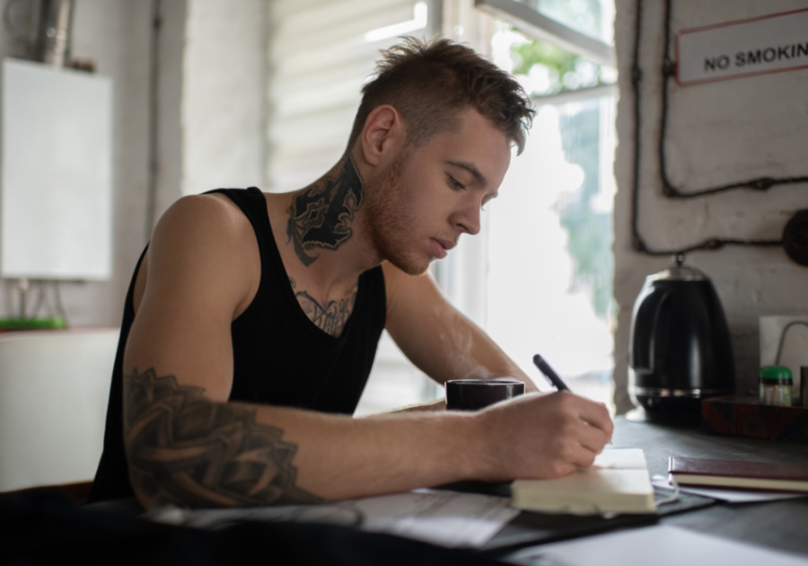 man writing on his journal questions to ask about self-esteem