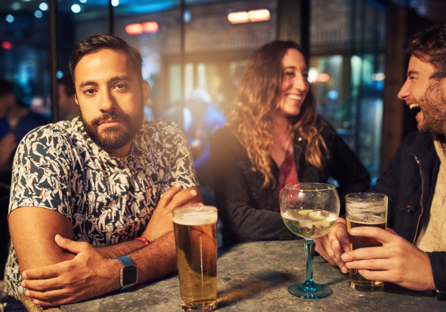 man in the bar with friends feeling indifferent signs people don't like you  