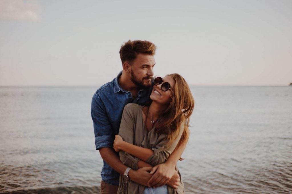 couple hugging near lake Signs of a Dominant Man 