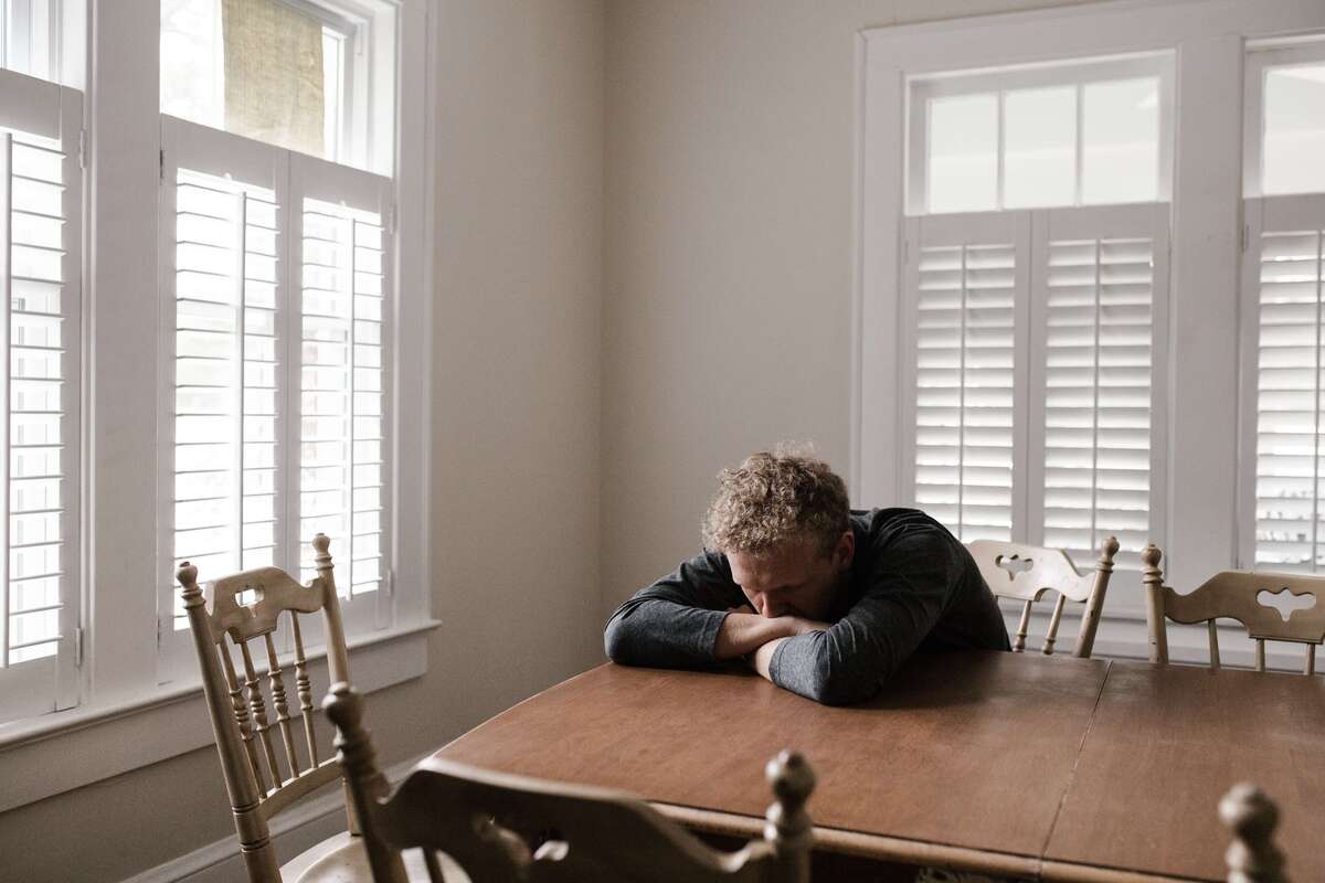 Man sitting at a table looking upset